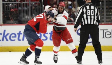 Washington Capitals right wing Brandon Duhaime (22) and Carolina Hurricanes defenseman Jalen Chatfield, center, fight during the first period of an NHL hockey game, Thursday, April 10, 2025, in Washington. (AP Photo/Nick Wass)