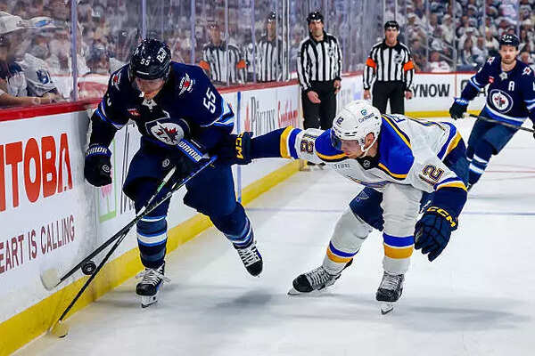 Mark Scheifele #55 of the Winnipeg Jets and Radek Faksa #12 of the St. Louis Blues chase the puck