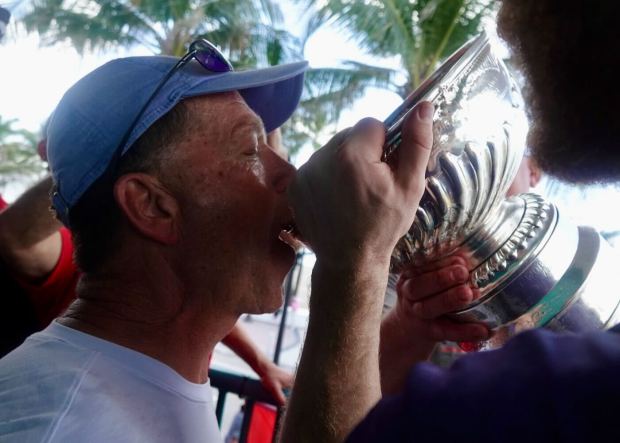 Fan Greg Swick drinks beer from the Stanley Cup as...
