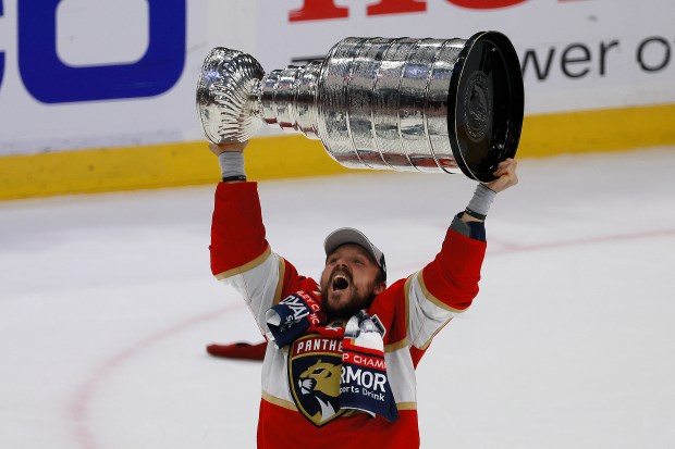 Panthers center Sam Reinhart hoists the Stanley Cup trophy after winning Game 7 of Stanley Cup Final at Amerant Bank Arena in Sunrise on June 24. (Mike Stocker/South Florida Sun Sentinel)