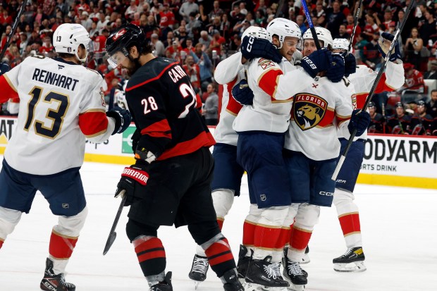 Florida Panthers' Carter Verhaeghe, right, celebrates his goal with teammate Aleksander Barkov (16), center with Sam Reinhart (13) and Carolina Hurricanes' William Carrier (28) nearby during the third period of Game 5 of the Stanley Cup Eastern Conference finals in Raleigh, N.C., Wednesday, May 28, 2025. (AP Photo/Karl DeBlaker)
