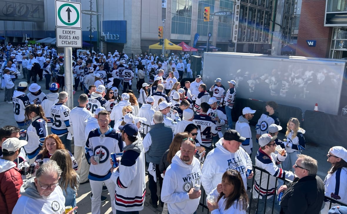 A group of people dressed in white filled a street closed down. 
