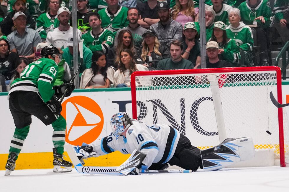 Dallas Stars left wing Jason Robertson, left, scores a goal on Utah Hockey Club goaltender...