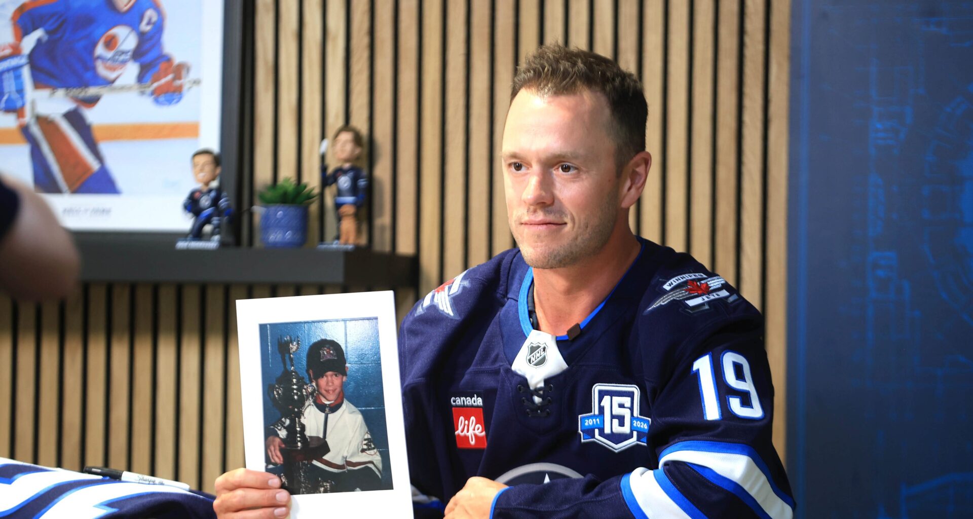 Winnipeg Jets forward Jonathan Toews holds a photo of himself as young hockey player during a press conference on Friday at Canada Life Centre on Friday to officially announce he had signed with his hometown team. (Ruth Bonneville/Winnipeg Free Press)