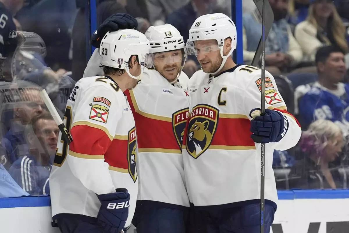 Florida Panthers center Sam Reinhart (13) celebrates his goal against the Tampa Bay Lightning with center Carter Verhaeghe (23) and center Aleksander Barkov (16) during the third period in Game 5 of an NHL hockey Stanley Cup first-round playoff series, Wednesday, April 30, 2025, in Tampa, Fla. (AP Photo/Chris O'Meara)