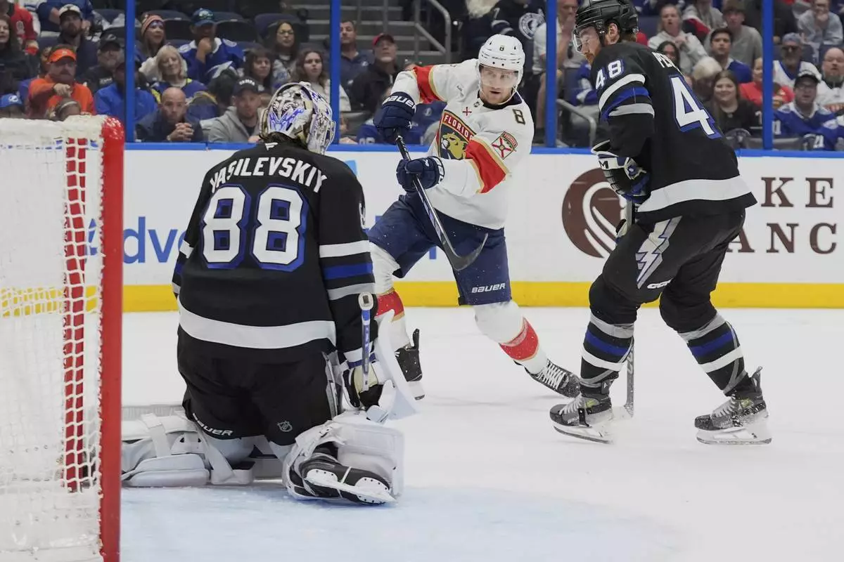 Florida Panthers center Nico Sturm (8) gets off a shot against Tampa Bay Lightning goaltender Andrei Vasilevskiy (88) and defenseman Nick Perbix (48) during the first period of an NHL hockey game Tuesday, April 15, 2025, in Tampa, Fla. (AP Photo/Chris O'Meara)