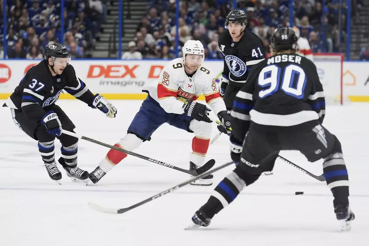 Florida Panthers center Sam Bennett (9) works against Tampa Bay Lightning defenseman J.J. Moser (90), center Yanni Gourde (37) and right wing Mitchell Chaffee (41) during the first period of an NHL hockey game Tuesday, April 15, 2025, in Tampa, Fla. (AP Photo/Chris O'Meara)