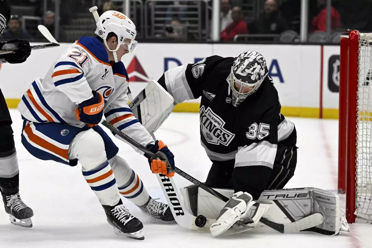 Los Angeles Kings goaltender Darcy Kuemper (35) stops a shot by Edmonton Oilers center Trent Frederic (21) during the first period of an NHL hockey game in Los Angeles, Saturday, April 5, 2025. (AP Photo/Alex Gallardo)