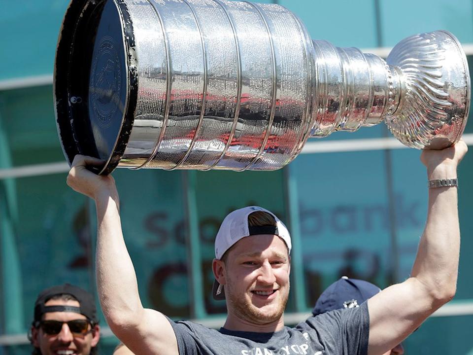  Colorado Avalanche forward Nathan MacKinnon holds up the Stanley Cup during his parade in Halifax on Saturday, August 20, 2022.