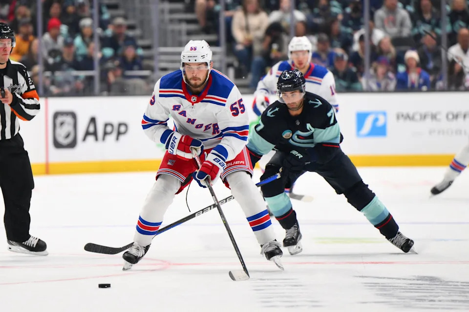 New York Rangers defenseman Ryan Lindgren (55) advances the puck while chased by Seattle Kraken right wing Jordan Eberle (7) during the second period at Climate Pledge Arena. Mandatory Credit: Steven Bisig-Imagn Images