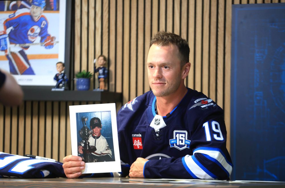 Winnipeg Jets forward Jonathan Toews holds a photo of himself as young hockey player during a press conference on Friday at Canada Life Centre on Friday to officially announce he had signed with his hometown team. (Ruth Bonneville/Winnipeg Free Press)