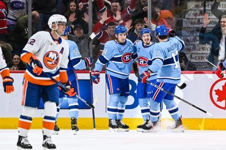 Feb 11, 2023; Montreal, Quebec, CAN; Montreal Canadiens center Nick Suzuki (14) celebrates his goal against the New York Islanders with left wing Raphael Harvey-Pinard (49) and right wing Josh Anderson (17) during the first period at Bell Centre. Mandatory Credit: David Kirouac-Imagn Images