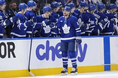 Toronto Maple Leafs defenseman Chris Tanev celebrating a goal being scored with the rest of his teammates. Toronto Maple Leafs defenseman Chris Tanev celebrating a goal being scored with the rest of his teammates.