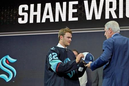 Jul 7, 2022; Montreal, Quebec, CANADA; Shane Wright is given a hat by Seattle Kraken general manager Ron Francis after being selected as the number four overall pick to the Seattle Kraken in the first round of the 2022 NHL Draft at Bell Centre. Mandatory Credit: Eric Bolte-Imagn Images