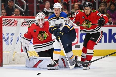 Sep 28, 2023; Chicago, Illinois, USA; St. Louis Blues forward Zachary Bolduc (76) battles for control of the puck with Chicago Blackhawks forward Connor Bedard (98) in front of goaltender Drew Commesso (29) in overtime at United Center. Mandatory Credit: Jamie Sabau-Imagn Images
