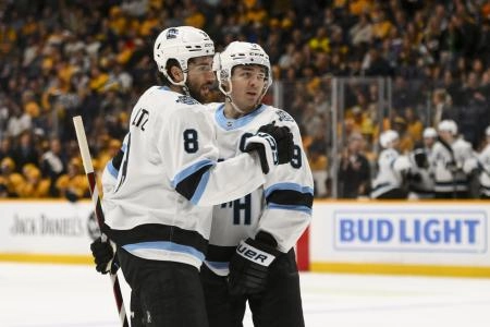 Apr 14, 2025; Nashville, Tennessee, USA; Utah Hockey Club center Nick Schmaltz (8) celebrates a goal with center Clayton Keller (9) against the Nashville Predators during the second period at Bridgestone Arena. Mandatory Credit: Steve Roberts-Imagn Images