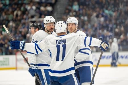 Toronto Maple Leafs trio of Max Domi, Auston Matthews, and Jake McCabe celebrating a goal being scored.
