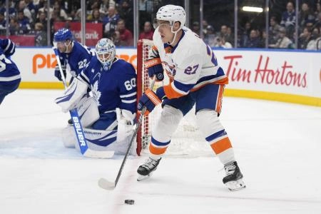 Dec 21, 2024; Toronto, Ontario, CAN; New York Islanders forward Anders Lee (27) looks topass the puck as Toronto Maple Leafs goaltender Joseph Woll (60) defends the goal during the second period at Scotiabank Arena. Mandatory Credit: John E. Sokolowski-Imagn Images