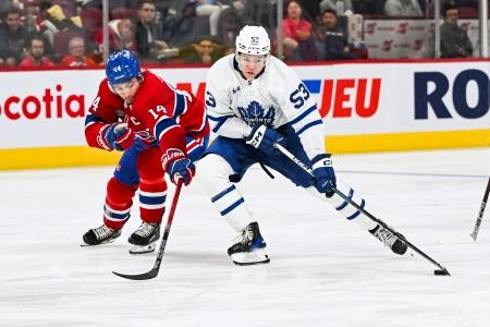 Sep 30, 2023; Montreal, Quebec, CAN; Toronto Maple Leafs right wing Easton Cowan (53) plays the puck against Montreal Canadiens center Nick Suzuki (14) during the third period at Bell Centre