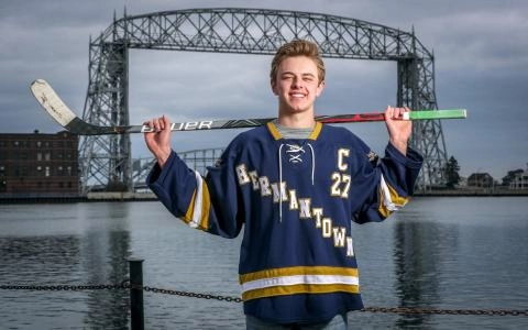 Blake Biondi holds a stick as he's pictured in front of the bridge