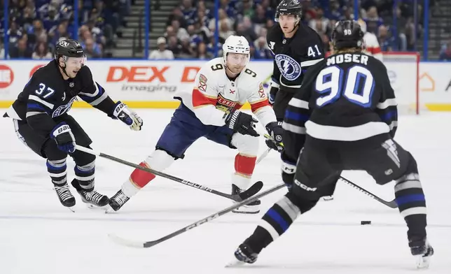 Florida Panthers center Sam Bennett (9) works against Tampa Bay Lightning defenseman J.J. Moser (90), center Yanni Gourde (37) and right wing Mitchell Chaffee (41) during the first period of an NHL hockey game Tuesday, April 15, 2025, in Tampa, Fla. (AP Photo/Chris O'Meara)