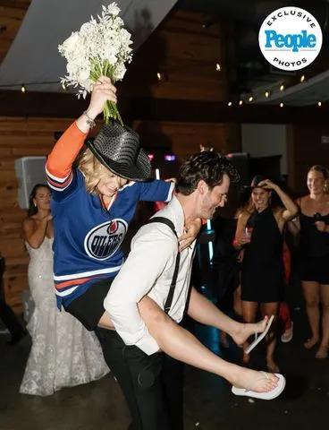 Brianna Chwala/The Unfiltered Collective  After winning the bouquet toss, Emma Maltais gets a piggyback ride from Benjamin Gleason
