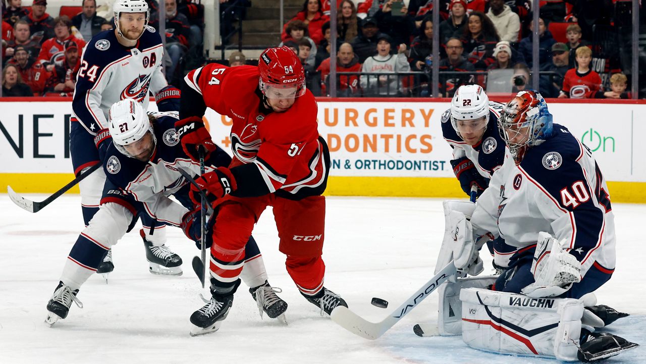 San Jose Sharks center Nico Sturm (7) and Columbus Blue Jackets left wing Dmitri Voronkov (10) reach for the puck in front of goaltender Alexandar Georgiev (40) in the first period of an NHL hockey game Thursday, Jan. 16, 2025, in Columbus, Ohio. (AP Photo/Sue Ogrocki)