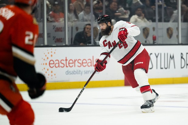 Carolina Hurricanes defenseman Brent Burns, right, shoots during the second period of an NHL hockey game against the Anaheim Ducks, Sunday, March 23, 2025, in Anaheim, Calif. (AP Photo/Kyusung Gong)