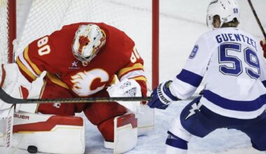 Tampa Bay Lightning's Jake Guentzel, right, has his shot blocked by Calgary Flames goalie Dan Vladar, left, during second-period NHL hockey game action in Calgary, Alberta, Thursday, Dec. 12, 2024. (Jeff McIntosh/The Canadian Press via AP)