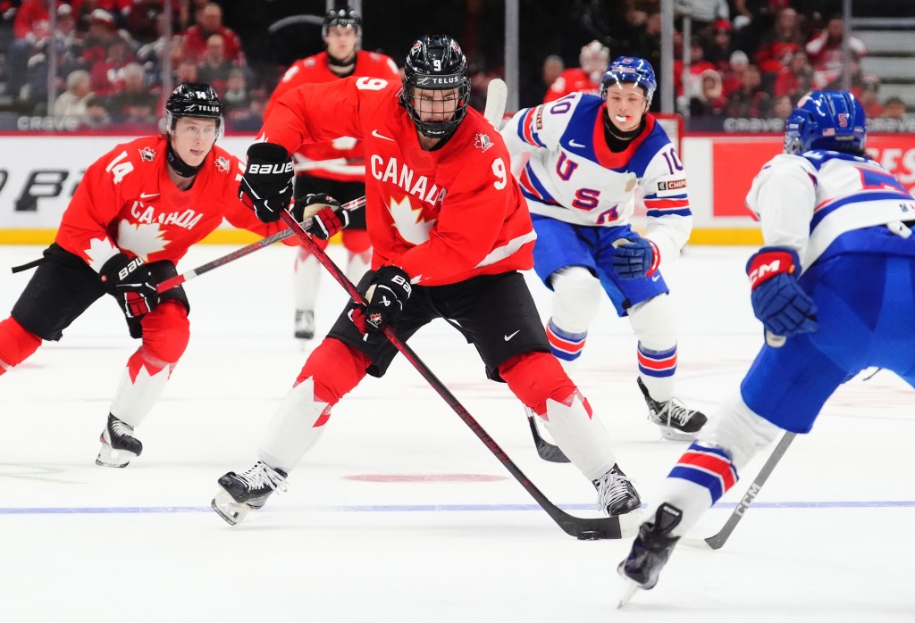 Canada's Gavin McKenna (9) skates with the puck as United States' Drew Fortescue (5) defends during the second period of an IIHF World Junior Hockey Championship tournament game in Ottawa, Ontario, Dec. 31, 2024. 
