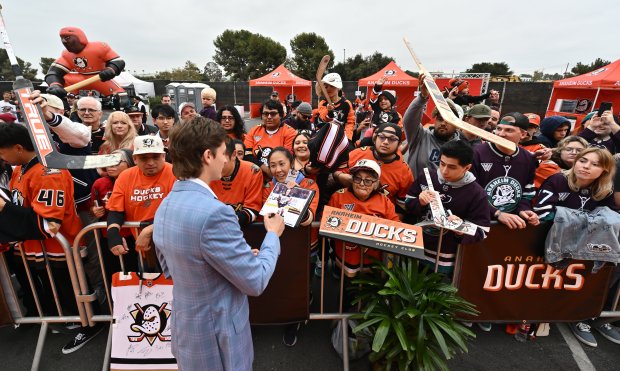 Ducks forward Trevor Zegras signs autographs for fans during the...