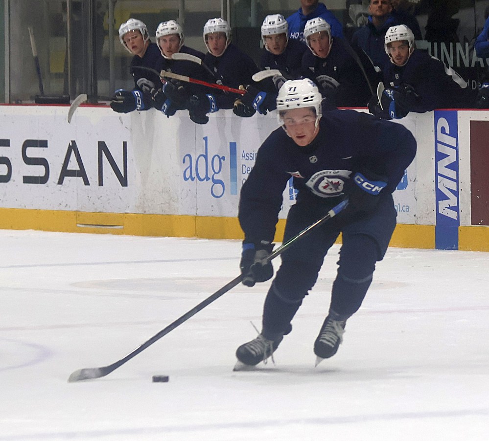 Owen Martin holds the puck at the line while fellow Jets prospects look on. (Cassidy Dankochik The Carillon)