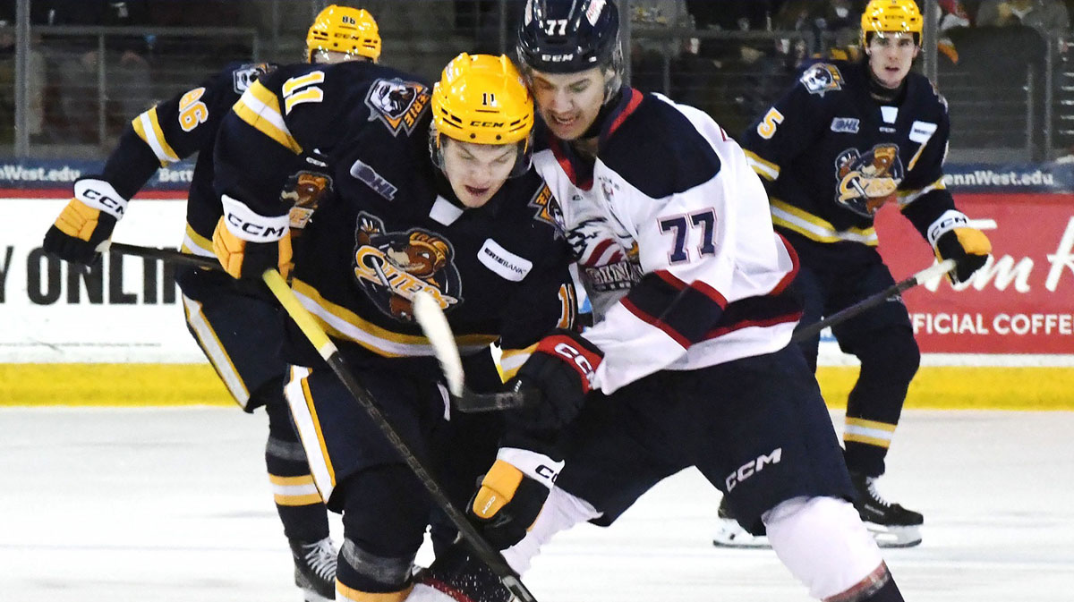 Erie Otters forward Dylan Edwards, leftt, competes against Saginaw Spirit forward Michael Misa during an Ontario Hockey League playoff game at Erie Insurance Arena in Erie on April 1, 2025.