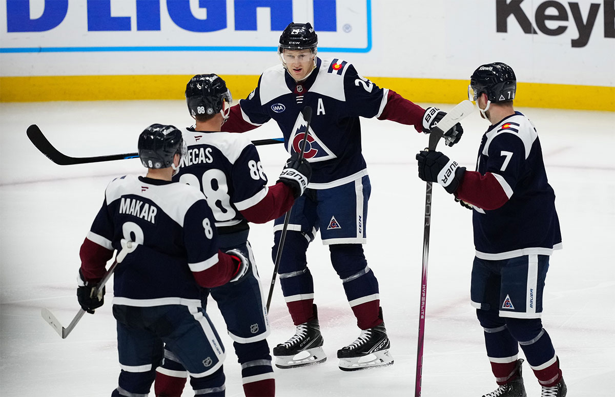 Colorado Avalanche center Nathan MacKinnon (29) celebrates an assist with center Martin Necas (88) and defenseman Devon Toews (7) and defenseman Cale Makar (8) in the third period against the Chicago Blackhawks at Ball Arena.