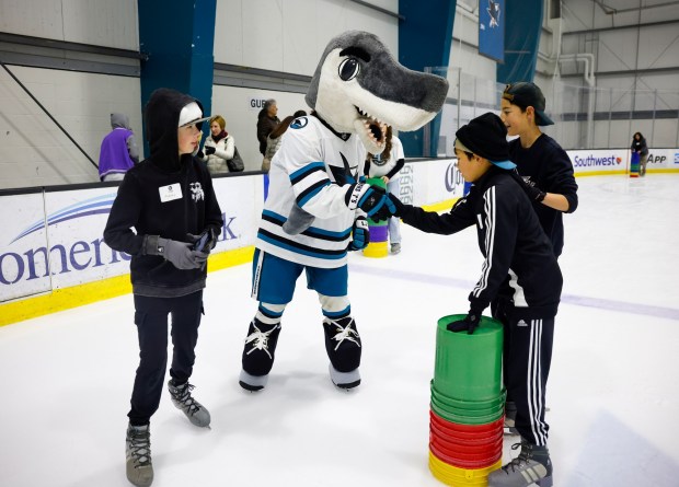 San Jose Sharks mascot SJ Sharkie shakes hands with Monteyo Racinez, 13, from San Jose, as Rodney Diridon, 13, left, from Santa Clara, and Luca Fidani, 13, from San Jose, watch on during the LKT1D Fund (Luke Kunin Type 1 Diabetes) Skating Party at Sharks Ice in San Jose, Calif., on Sunday, Jan. 26, 2025. (Nhat V. Meyer/Bay Area News Group)