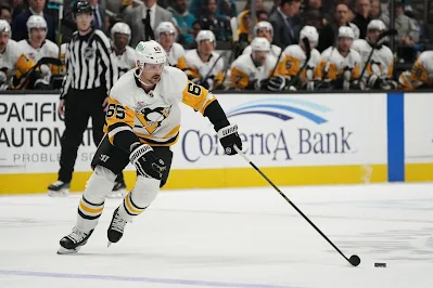 Pittsburgh Penguins defenseman Erik Karlsson skates with the puck during 2025 game.