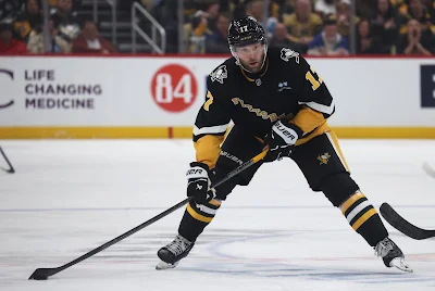 Pittsburgh Penguins forward Bryan Rust skates with the puck during 2025 game.