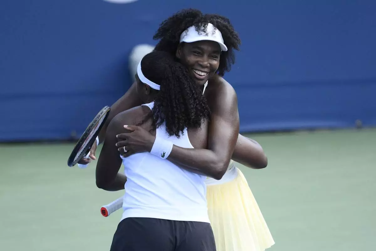 Venus Williams, right, hugs her doubles partner Hailey Baptiste, left, after they defeated Eugenie Bouchard and Clervie Ngounoue in a doubles match at the Citi Open tennis tournament Monday, July 21, 2025, in Washington. (AP Photo/Nick Wass)