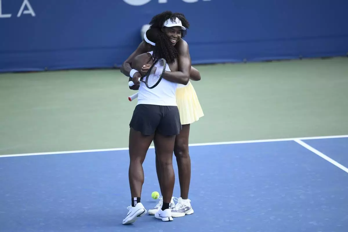Venus Williams, right, hugs her doubles partner Hailey Baptiste, left, after they defeated Eugenie Bouchard and Clervie Ngounoue in a doubles match at the Citi Open tennis tournament Monday, July 21, 2025, in Washington. (AP Photo/Nick Wass)