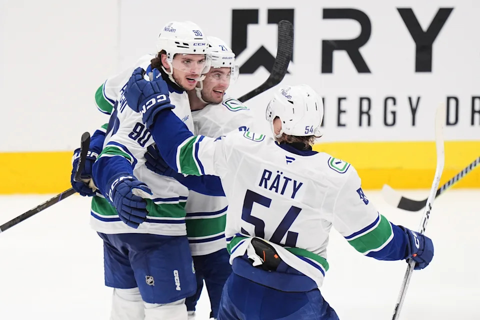 Vancouver Canucks' Victor Mancini (90), Nils Hoglander, center, and Aatu Raty (54) celebrate after Mancini scored on a power-play against the Dallas Stars in the third period of an NHL hockey game in Dallas, Tuesday, April 8, 2025. (AP Photo/LM Otero)