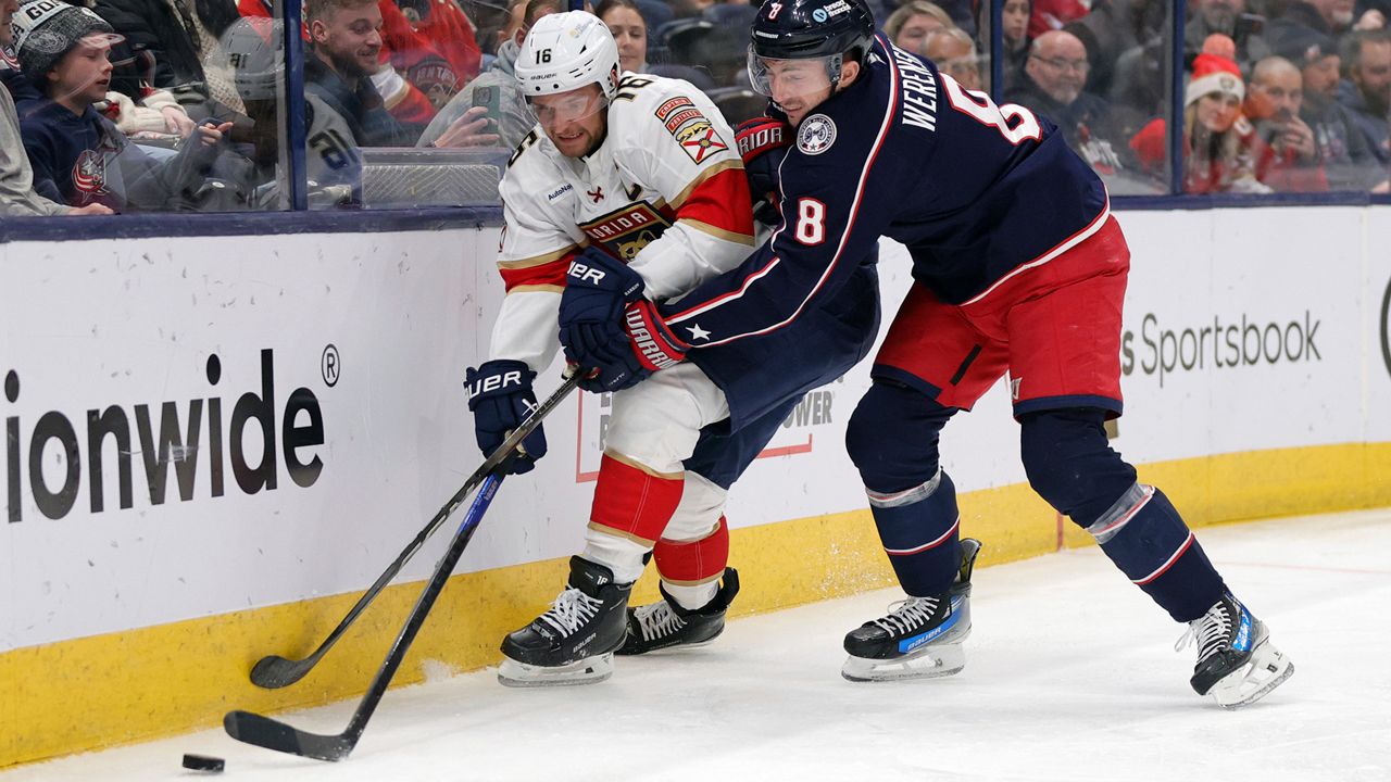 Florida Panthers forward Aleksander Barkov, left, reaches for the puck in front of Columbus Blue Jackets defenseman Zach Werenski, right, during the first period an NHL hockey game in Columbus, Ohio, Thursday, March 20, 2025. (AP Photo/Paul Vernon)