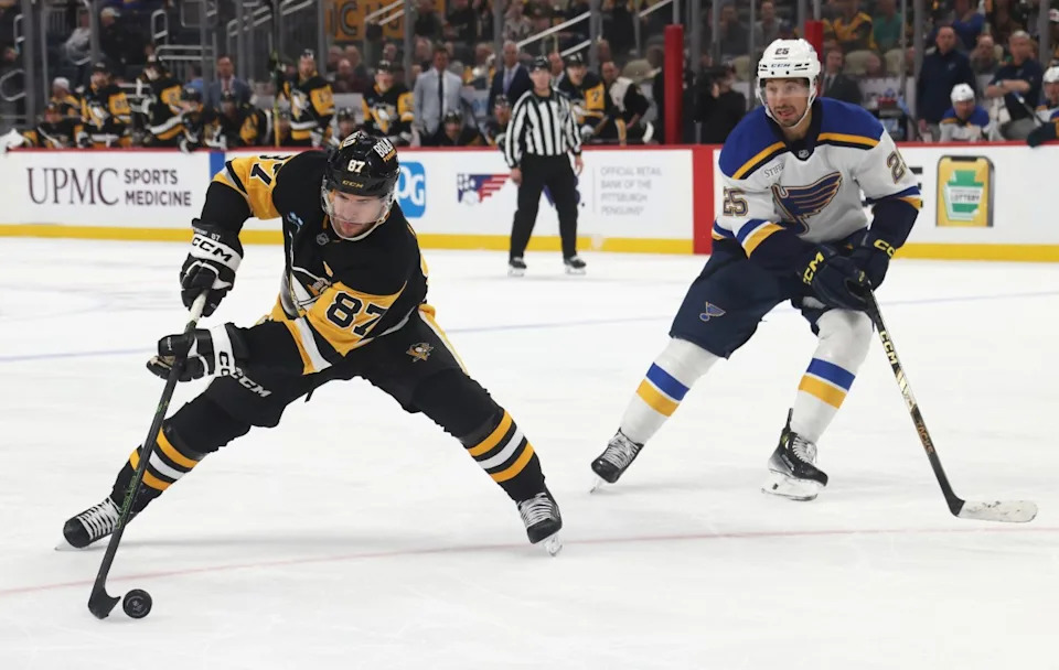 Pittsburgh Penguins center Sidney Crosby (87) moves the puck against St. Louis Blues center Jordan Kyrou (25) during the third period at PPG Paints Arena. Charles LeClaire-Imagn Images