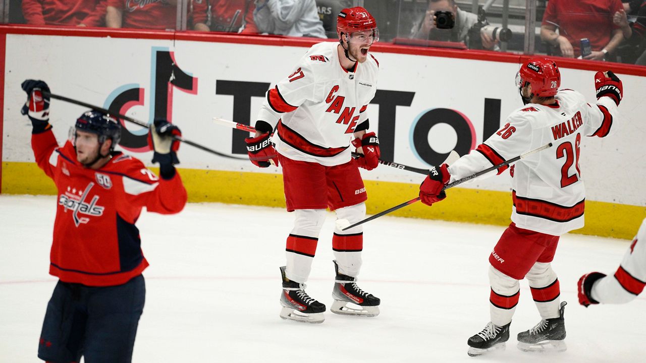 Carolina Hurricanes right wing Andrei Svechnikov (37) celebrates his goal with defenseman Sean Walker (26) in the third period of Game 5 of a second-round NHL hockey playoff series against the Washington Capitals Thursday, May 15, 2025, in Washington. (AP Photo/Nick Wass)