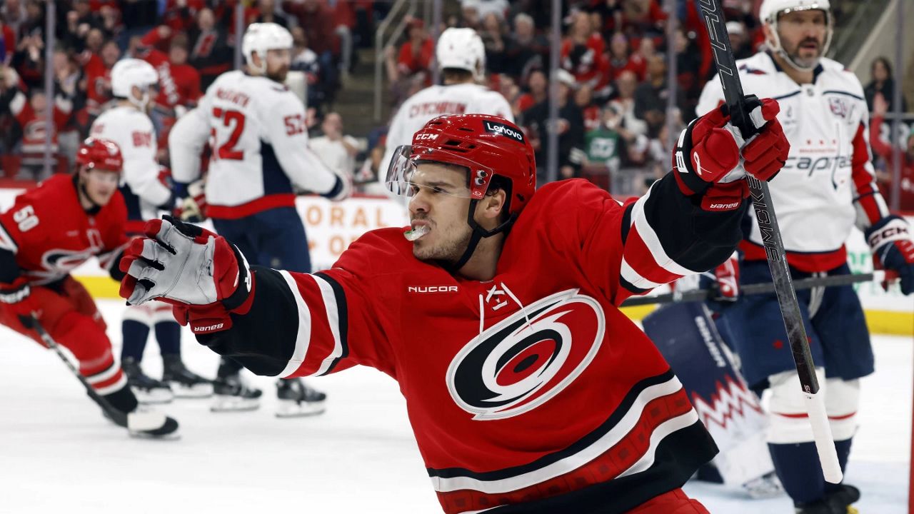 Carolina Hurricanes' Logan Stankoven (22) celebrates his goal with Washington Capitals' Alex Ovechkin (8) nearby during the second period of an NHL hockey game in Raleigh, N.C., Wednesday, April 2, 2025. (AP Photo/Karl DeBlaker)