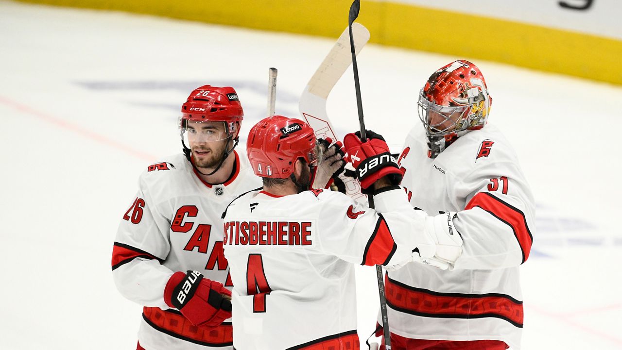 Carolina Hurricanes goaltender Frederik Andersen, right, celebrates with defenseman Shayne Gostisbehere (4) and defenseman Sean Walker (26) after Game 5 of a second-round NHL hockey playoff series against the Washington Capitals Thursday, May 15, 2025, in Washington. (AP Photo/Nick Wass)