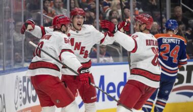 Carolina Hurricanes' Eric Robinson, Martin Necas (88) and Jesperi Kotkaniemi (82) celebrate a goal against the Edmonton Oilers during the third period of an NHL hockey game in Edmonton, Alberta, on Tuesday, Oct. 22, 2024. (Jason Franson/The Canadian Press via AP)