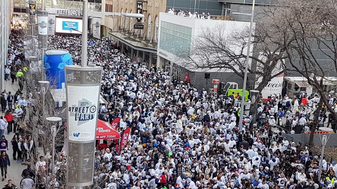 A crowd of people seen from above, the majority decked out in white costumes.