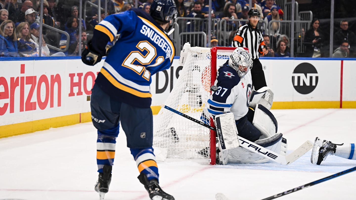 May 2, 2025; St. Louis, Missouri, USA; St. Louis Blues right wing Jimmy Snuggerud (21) is unable to score past Winnipeg Jets goaltender Connor Hellebuyck (37) during the second period in game six of the first round of the 2025 Stanley Cup Playoffs at Enterprise Center. Mandatory Credit: Connor Hamilton-Imagn Images