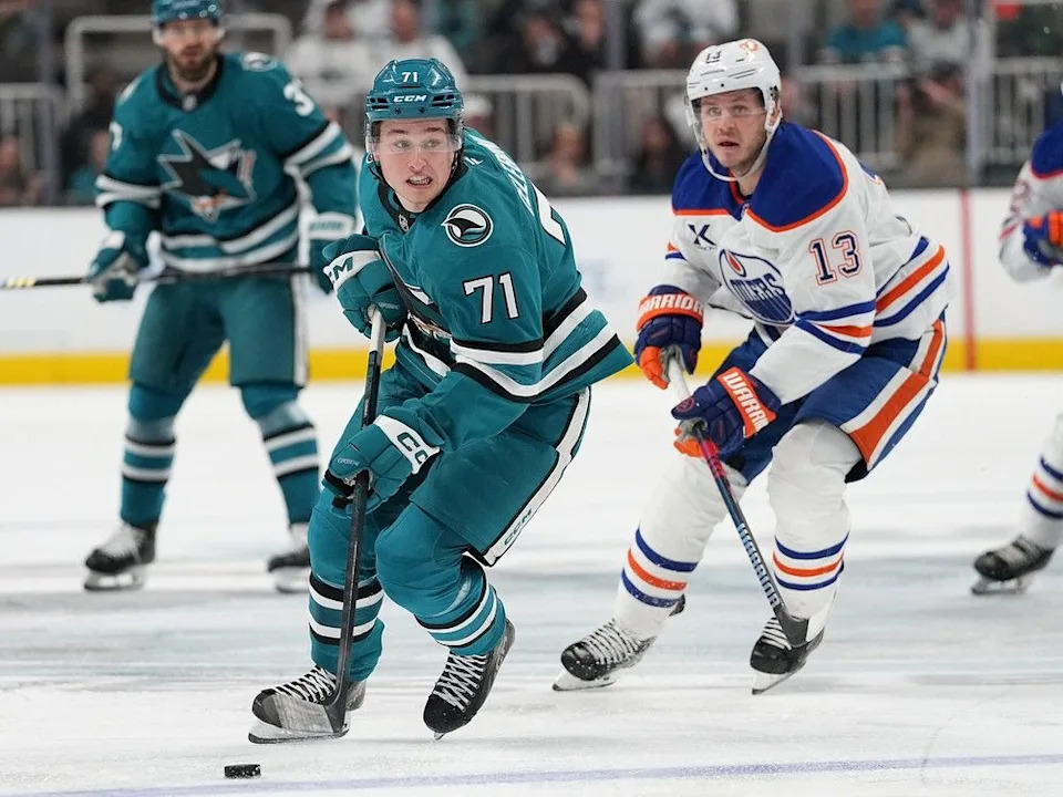 Macklin Celebrini #71 of the San Jose Sharks skates with the puck as he is pursued by Mattias Janmark #13 of the Edmonton Oilers in the second period at SAP Center on April 16, 2025 in San Jose, California.