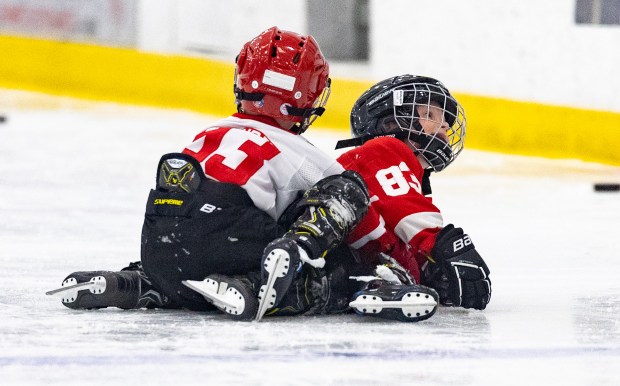 Archie DeBrincat, left, and Patrick Kane III wrestle on the ice during Patrick Kane Day on Aug. 8, 2025 at Johnny's Ice House West. (Dominic Di Palermo/Chicago Tribune)